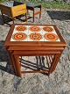Indskudsborde i teak med kakler.
Kr. 2.200,-